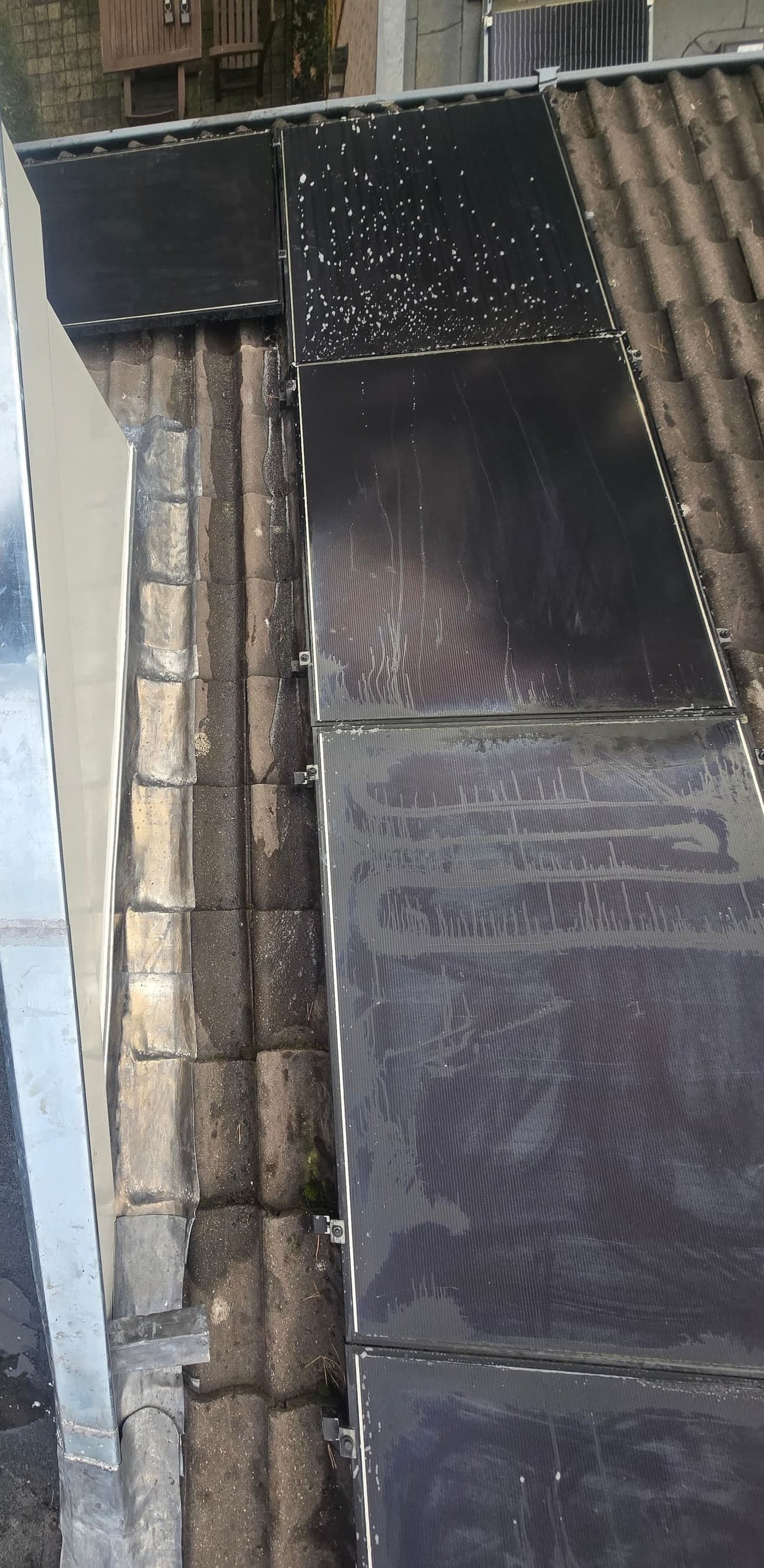 Zink- en loodwerk op de overgang van een plat dak naar een pannendak met zonnepanelen